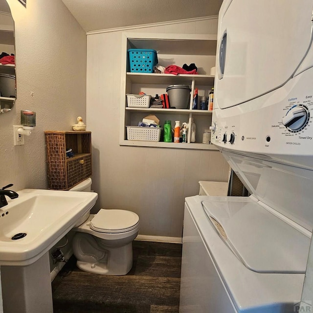 1819 W Arroyo Ave, Pueblo, CO 81004 - half bathroom with stacked washing machine and dryer, wood finished floors, and a textured wall