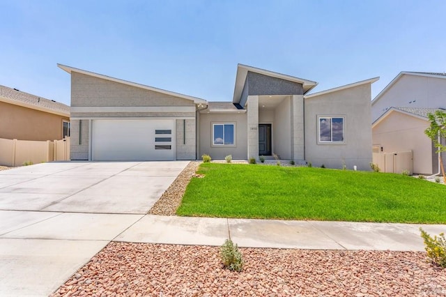 view of front facade featuring a garage, concrete driveway, stucco siding, fence, and a front yard