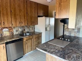 2013 Elmwood Ln, Pueblo, CO 81005 - kitchen with stainless steel dishwasher, white refrigerator with ice dispenser, a sink, backsplash, and brown cabinetry