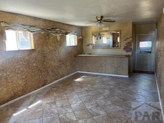 2013 Elmwood Ln, Pueblo, CO 81005 - kitchen with ceiling fan, baseboards, and stone finish floors