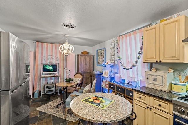 424 Mcclelland Ave, Pueblo, CO 81005 - kitchen featuring stainless steel fridge with ice dispenser, a chandelier, cream cabinets, a textured ceiling, and dark stone counters