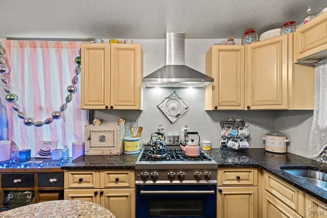 424 Mcclelland Ave, Pueblo, CO 81005 - kitchen with gas stove, wall chimney range hood, a sink, dark stone countertops, and cream cabinets