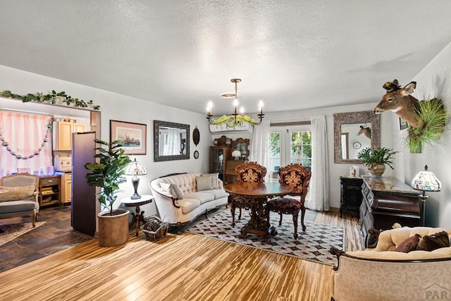 424 Mcclelland Ave, Pueblo, CO 81005 - living area with a chandelier, a textured ceiling, and wood finished floors