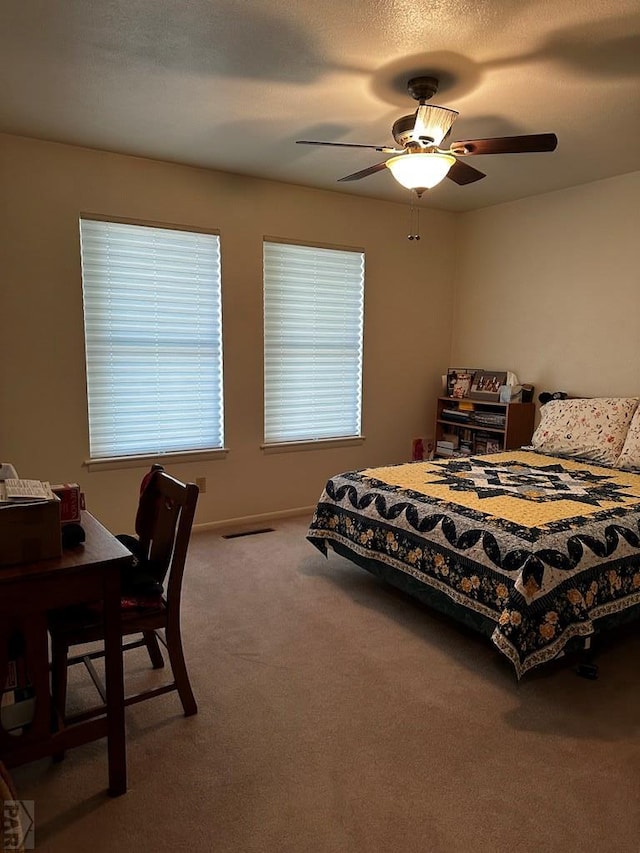 bedroom with visible vents, baseboards, ceiling fan, carpet, and a textured ceiling