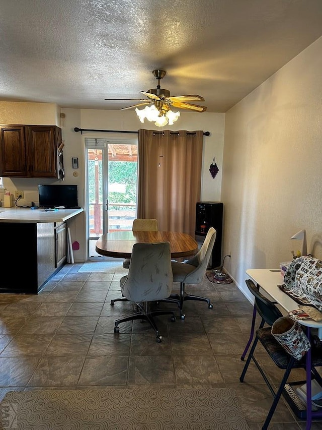 dining area featuring a ceiling fan and a textured ceiling