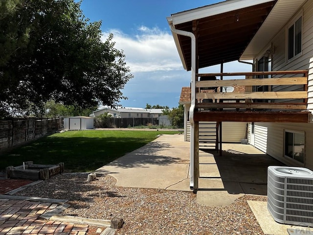 view of yard featuring a fenced backyard, an outdoor structure, central air condition unit, a patio area, and a shed