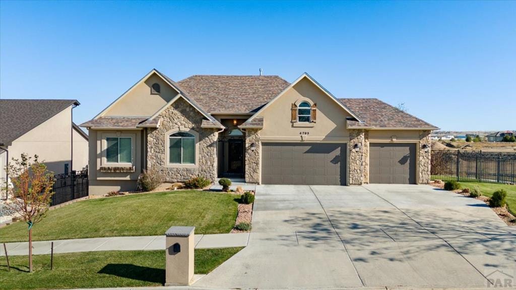 view of front of property featuring stucco siding, fence, concrete driveway, and a front yard