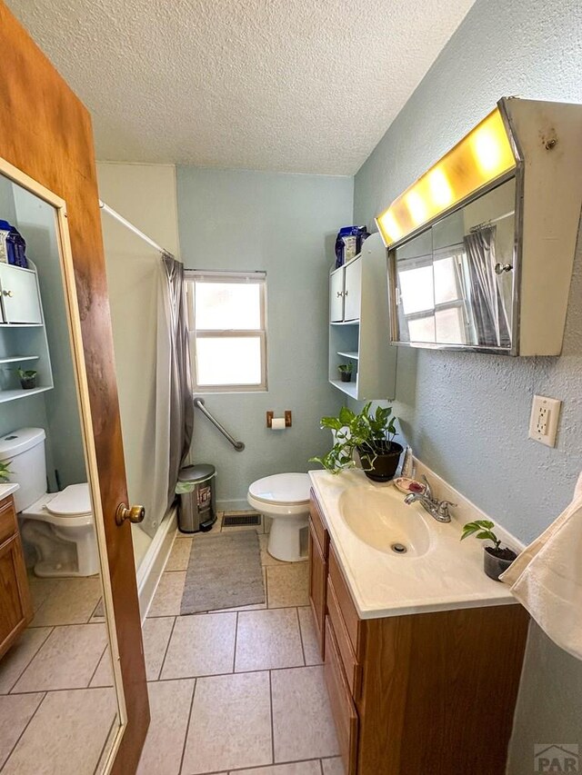 full bath featuring toilet, visible vents, a shower with shower curtain, and vanity