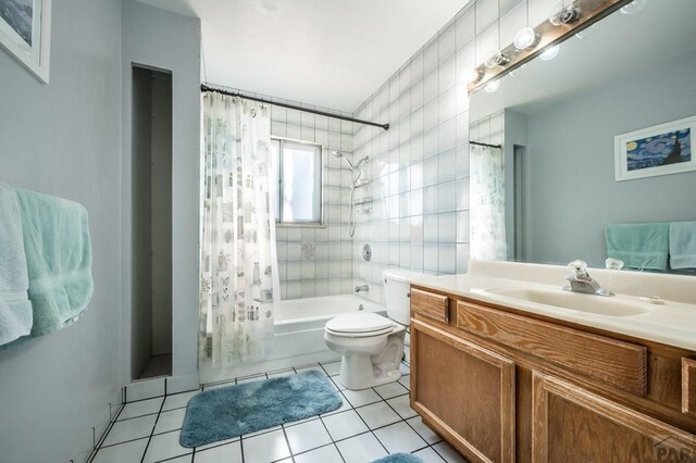 bathroom featuring shower / tub combo, toilet, tile patterned floors, vanity, and tile walls