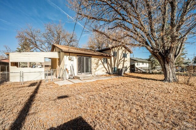 back of property with fence and stucco siding