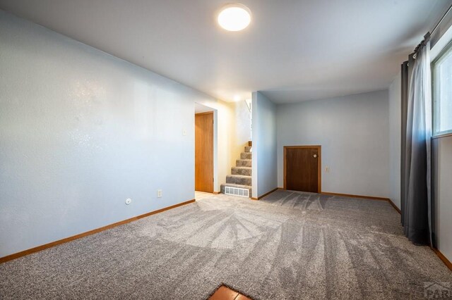 empty room with baseboards, stairs, visible vents, and carpet flooring