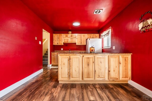 kitchen featuring freestanding refrigerator, visible vents, dark wood finished floors, and light brown cabinetry