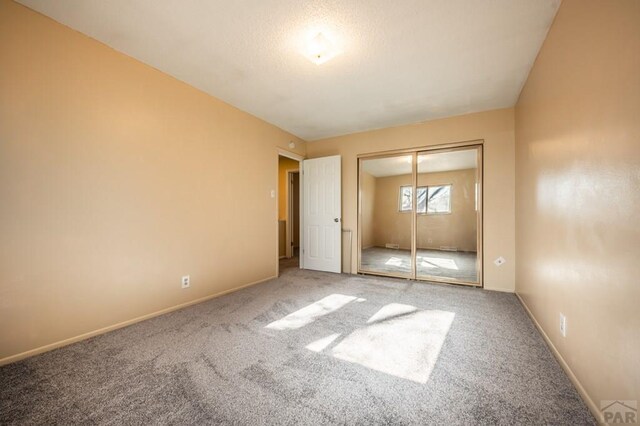 unfurnished bedroom featuring a closet, carpet, and baseboards