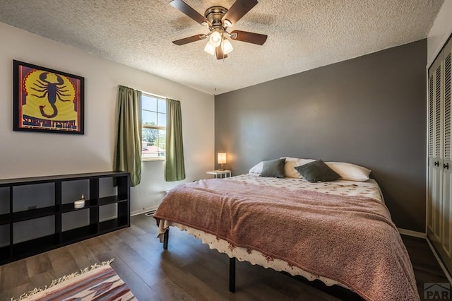 bedroom with a textured ceiling, ceiling fan, wood finished floors, baseboards, and a closet