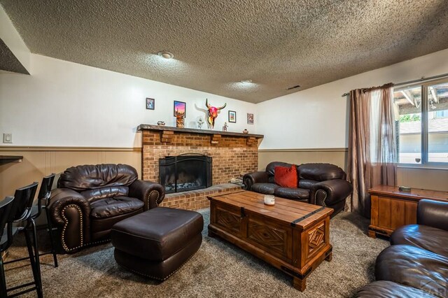 living room featuring a textured ceiling, a wainscoted wall, a fireplace, visible vents, and carpet