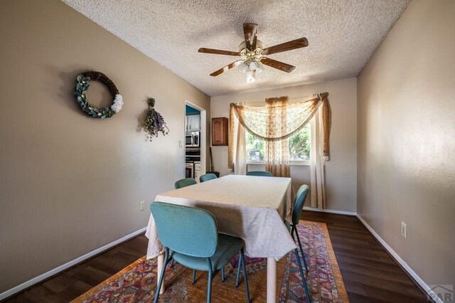 dining space featuring a ceiling fan, dark wood finished floors, and baseboards