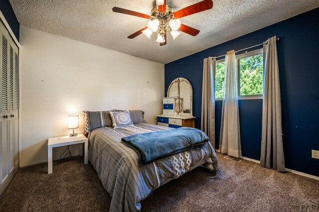 bedroom with baseboards, visible vents, dark carpet, and a textured ceiling