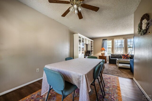 dining room with dark wood-style floors, baseboards, and a textured ceiling