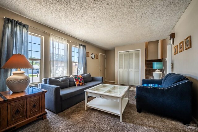 living area with a textured ceiling and dark colored carpet