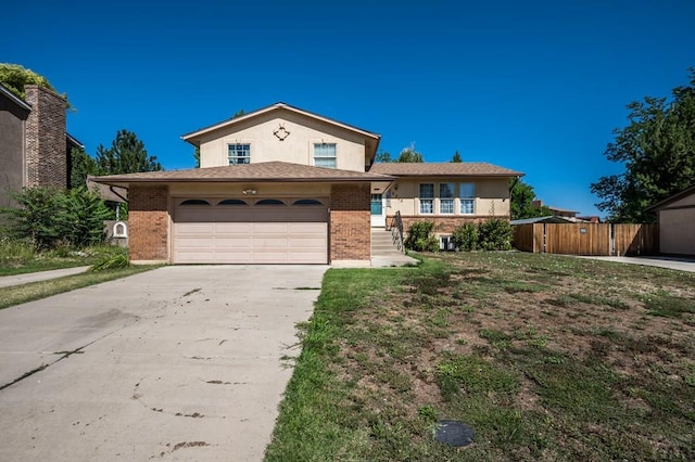 tri-level home with concrete driveway, brick siding, and an attached garage