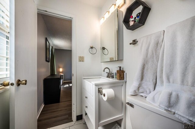 bathroom with toilet, baseboards, and a sink