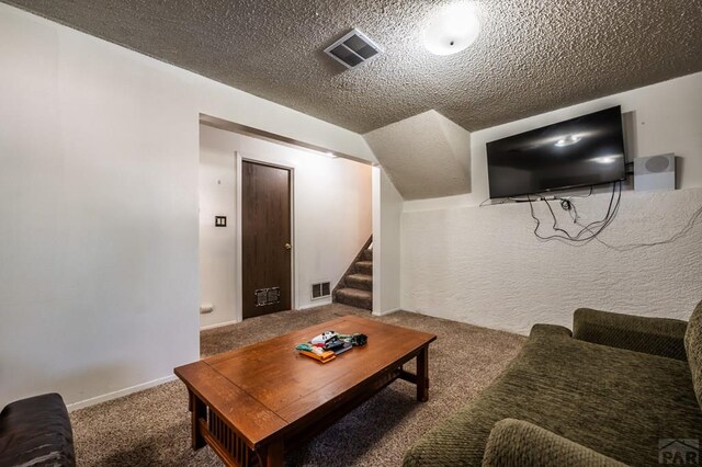 living room featuring stairway, carpet, visible vents, and a textured ceiling