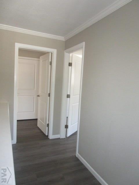 hall featuring ornamental molding, dark wood-style flooring, and baseboards