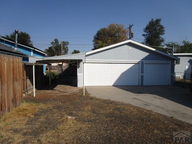 garage featuring a detached garage and fence