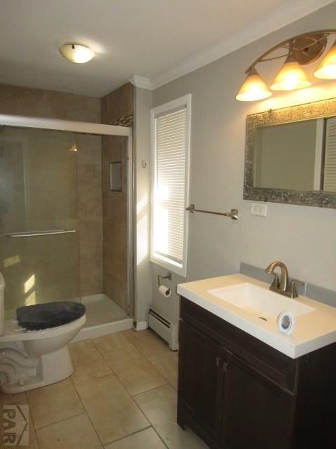 full bathroom with crown molding, toilet, baseboard heating, vanity, and tile patterned flooring