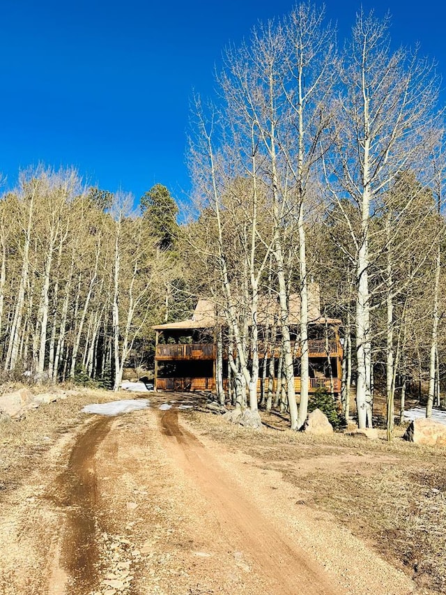 834 Ponderosa Rd, Cuchara, CO 81055 - view of front facade with dirt driveway, a deck, and a wooded view