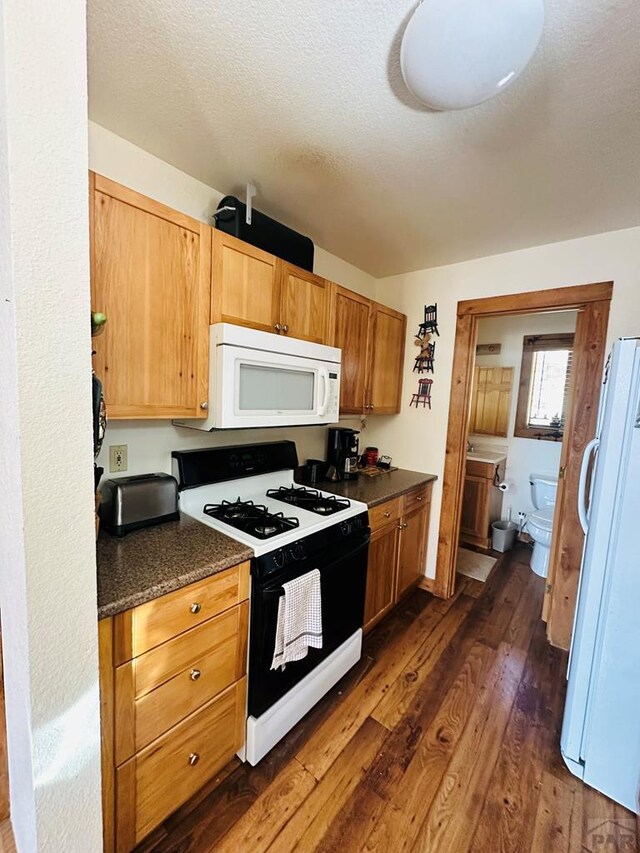 834 Ponderosa Rd, Cuchara, CO 81055 - kitchen with white appliances, dark countertops, and dark wood-type flooring