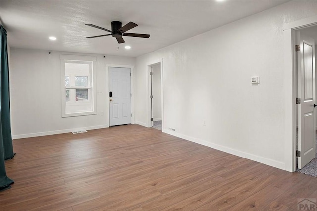 unfurnished room with a ceiling fan, wood finished floors, recessed lighting, and baseboards