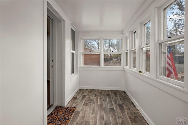 unfurnished sunroom featuring wood finished floors and baseboards