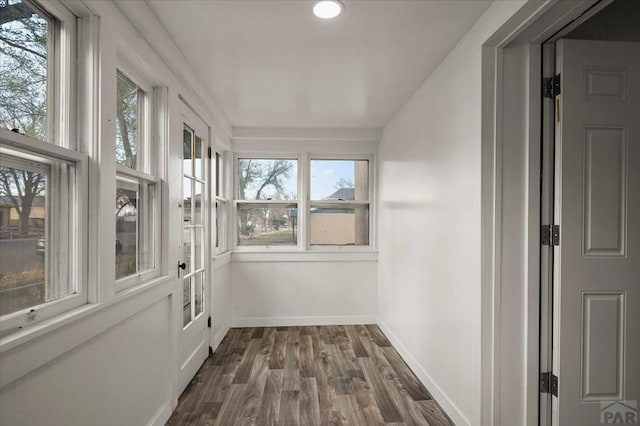 unfurnished sunroom with wood finished floors, baseboards, and recessed lighting