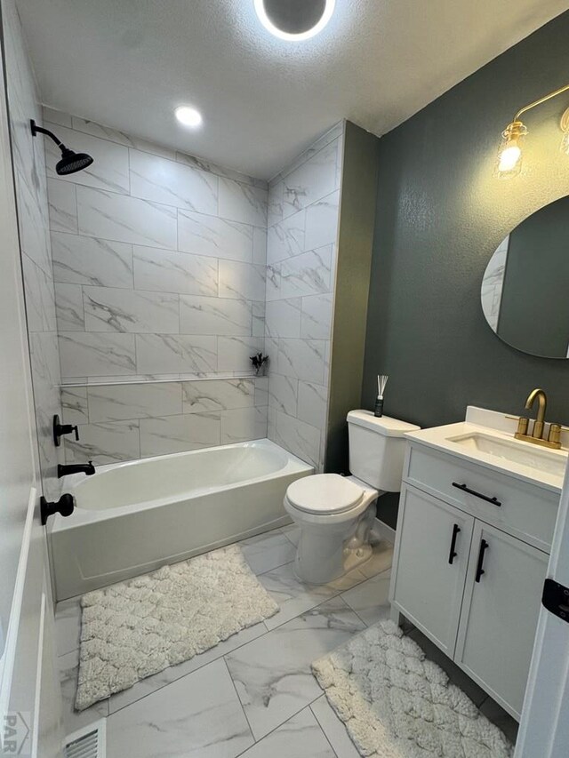 full bathroom featuring marble finish flooring, toilet, shower / bathtub combination, vanity, and a textured ceiling