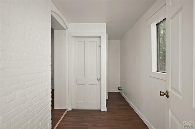 hallway with dark wood finished floors and baseboards