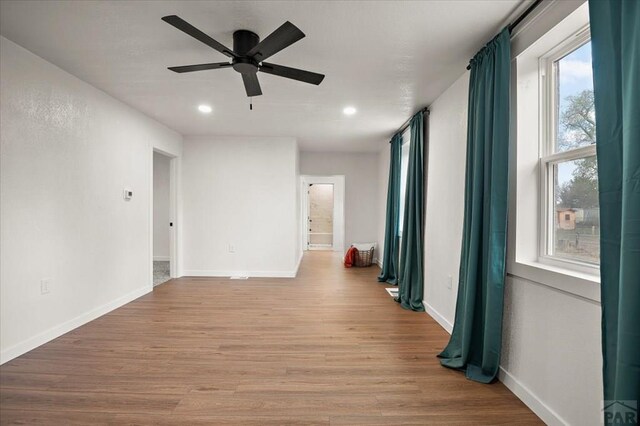 spare room with a ceiling fan, light wood-type flooring, recessed lighting, and baseboards