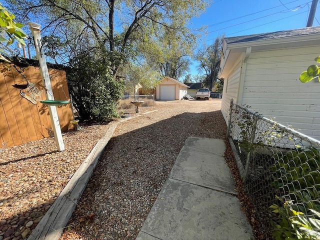 view of yard featuring an outdoor structure, fence, and a garage