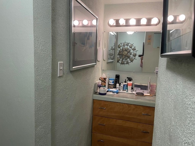 bathroom with vanity and a textured wall