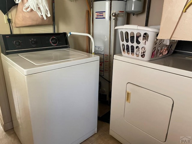 laundry area featuring laundry area, light tile patterned floors, independent washer and dryer, and water heater
