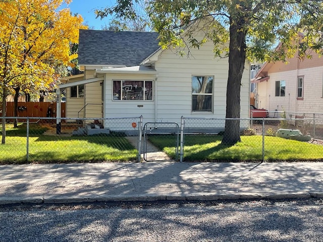 view of front facade featuring a fenced front yard, roof with shingles, a front lawn, and a gate