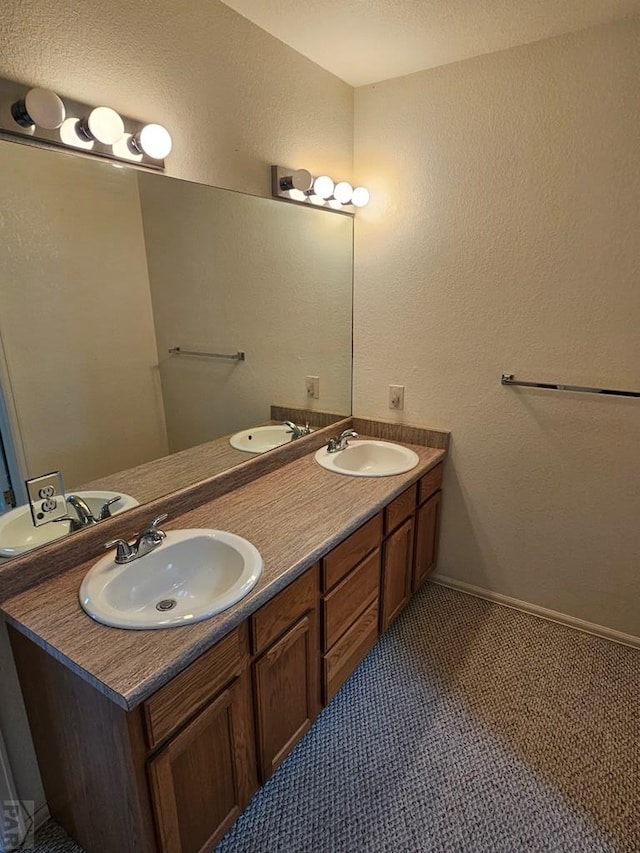 full bathroom featuring double vanity, a sink, and baseboards