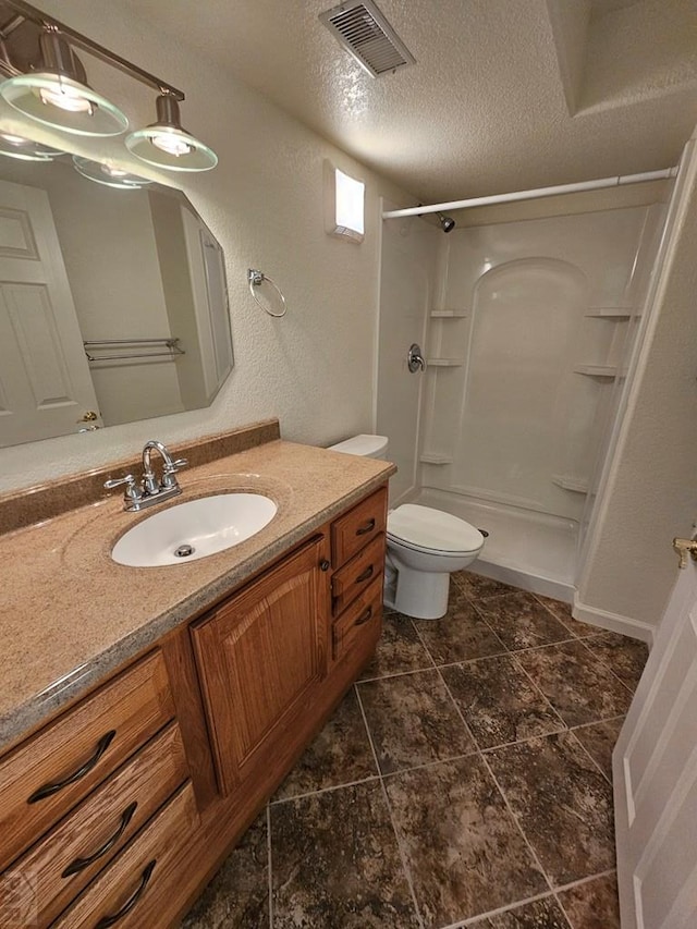 full bath featuring a textured ceiling, visible vents, toilet, vanity, and a walk in shower
