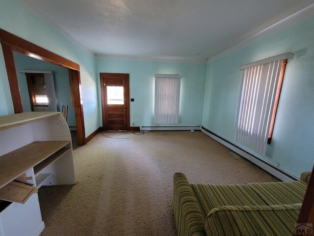 interior space with carpet floors, a baseboard radiator, and baseboards