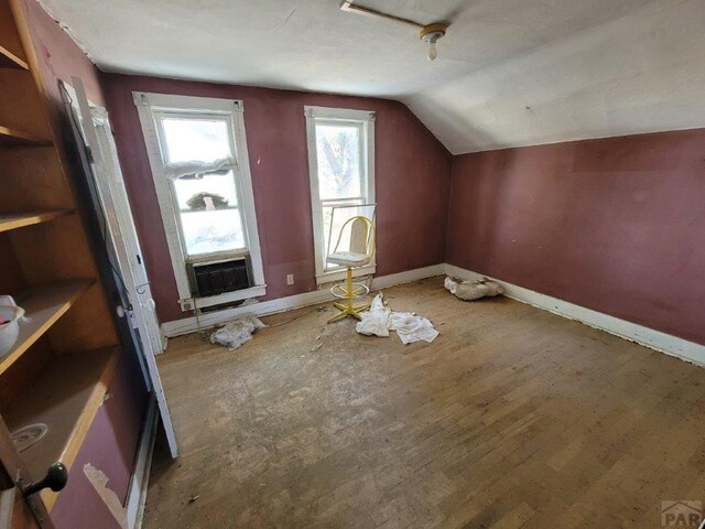 bonus room featuring lofted ceiling, cooling unit, wood finished floors, and baseboards