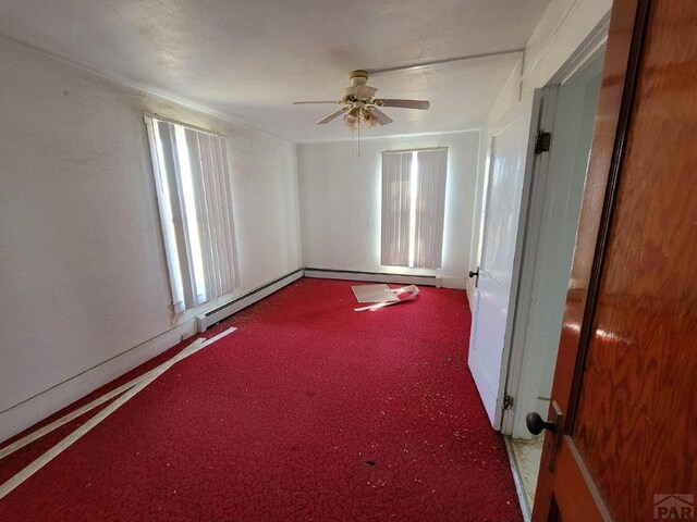 spare room featuring ceiling fan, baseboard heating, and carpet