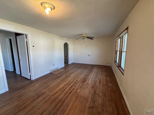 303 8th St, Fowler, CO 81039 - unfurnished room featuring arched walkways, a ceiling fan, wood finished floors, and baseboards