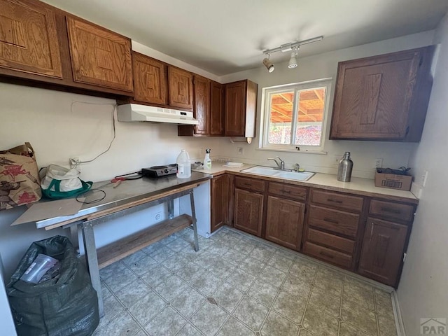 303 8th St, Fowler, CO 81039 - kitchen with under cabinet range hood, a sink, light countertops, and light flooring