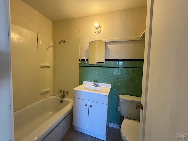 303 8th St, Fowler, CO 81039 - bathroom featuring vanity, toilet, shower / washtub combination, and tile walls