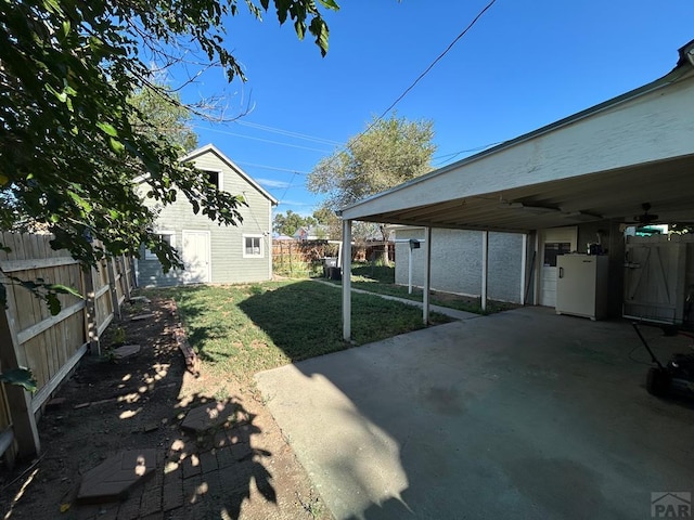 view of yard featuring an outdoor structure, a patio, and a fenced backyard